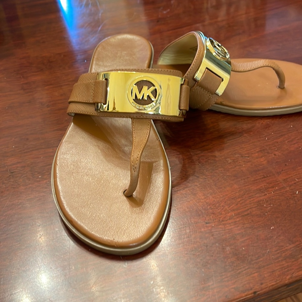 Michael Kors flip flop with gold hardware.